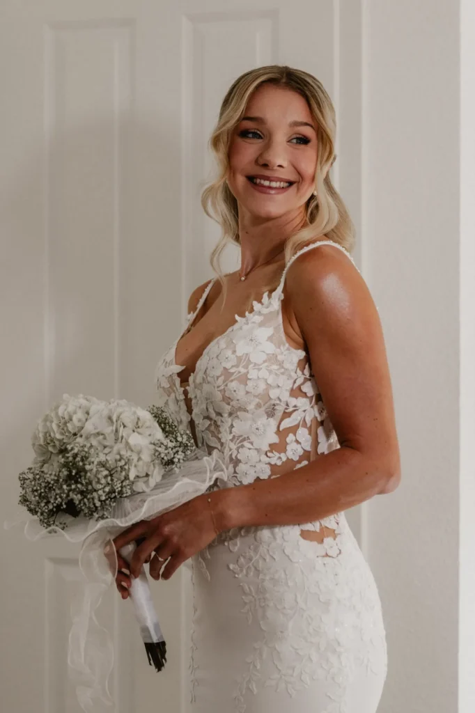 braut portrait laechelt brautstrauss hortensien spitzenkleid